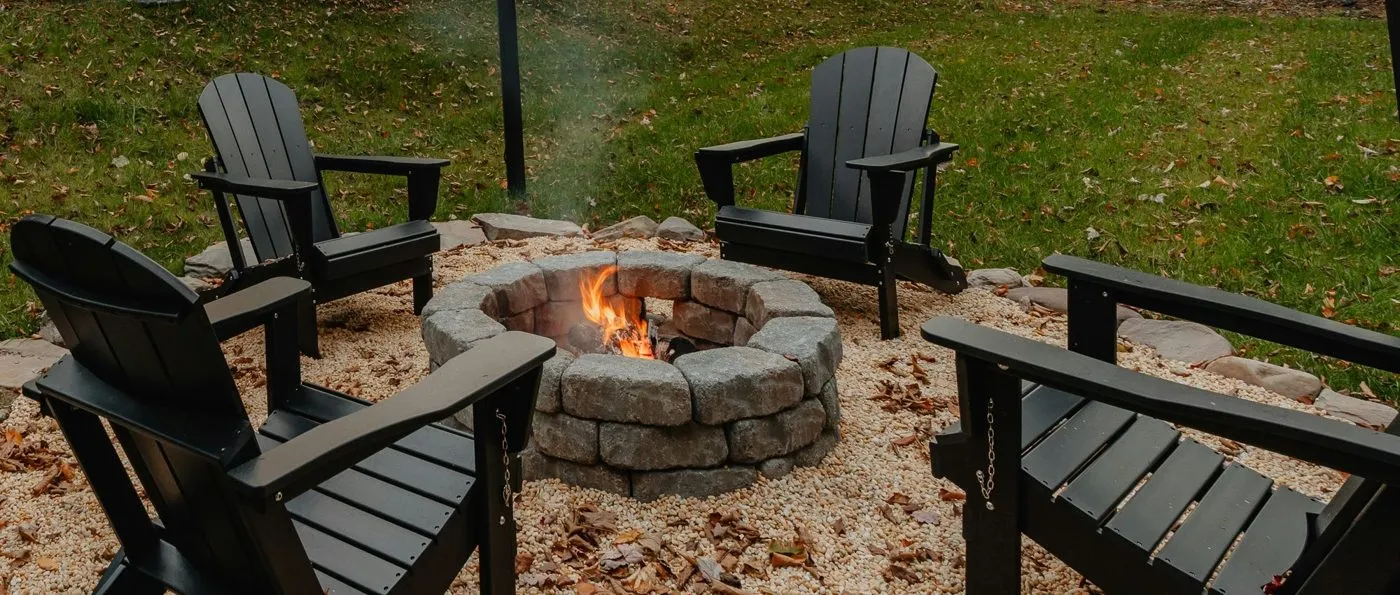 Adirondack chairs around a stone fire pit